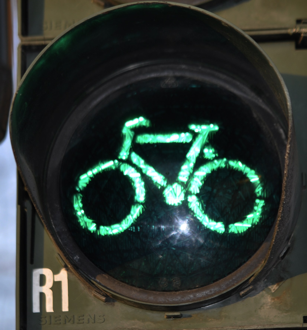 Grünes Ampelsignal mit Fahrradsymbol an einer Wand.