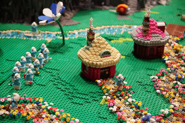 Ein Lego-Modell einer Kleinstadt mit Blumen, Spielzeugen, Häusern, Pflanzen und anderen Gegenständen mit einem leicht unscharfen Hintergrund.