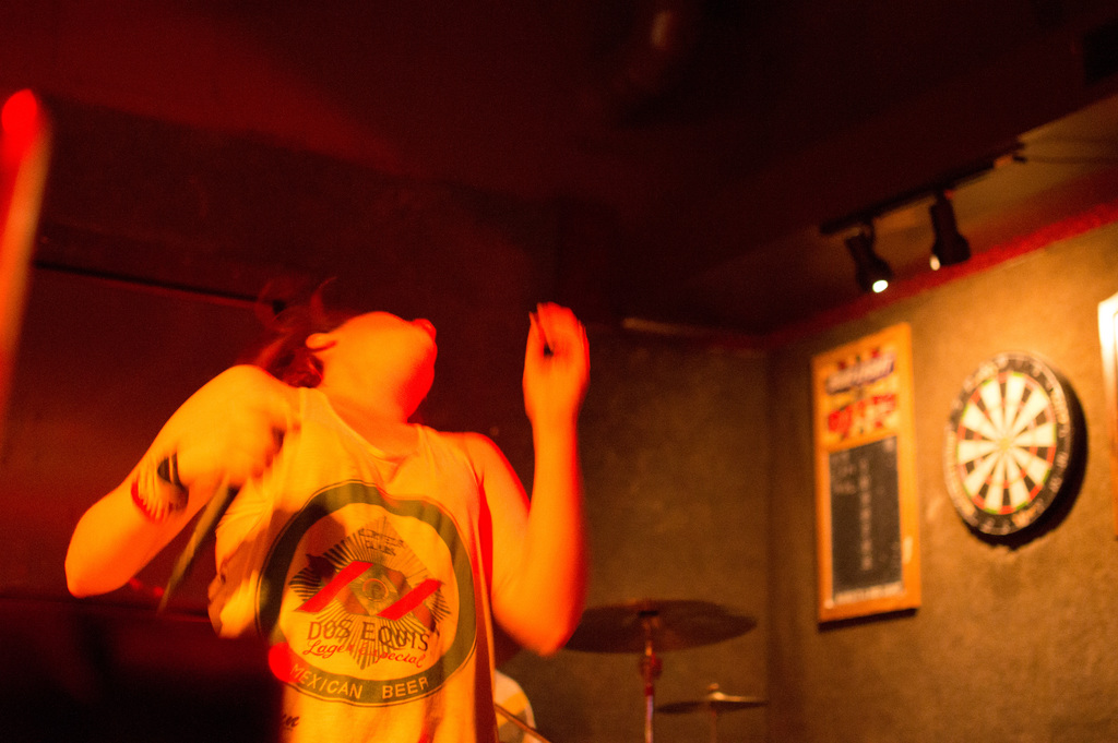 Eine Person tanzt in einem Oberteil, mit sichtbaren Lichtern auf der rechten Seite.