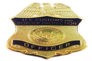 Goldabzeichen mit "U.S. Customs and Border Protection Officer"-Text auf einem weißen Hintergrund.
