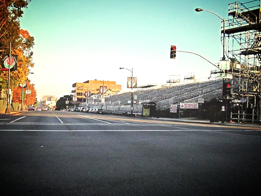 Eine Straße mit einer Verkehrsampel und Gerät auf der rechten Seite, Warnschilder und mehrere Fahrzeuge auf der linken Seite sowie Bäume im Hintergrund.