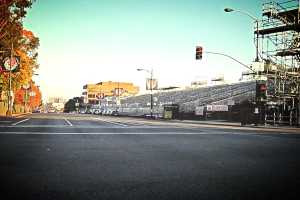 Eine Straße mit einer Verkehrsampel und Gerät auf der rechten Seite, Warnschilder und mehrere Fahrzeuge auf der linken Seite sowie Bäume im Hintergrund.