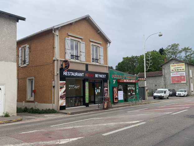 Straßensicht mit parkenden Autos, Gebäuden, Laternen, Bäumen und einem bewölkten Himmel, mit einem Schild "Lokale kommerzielle Verkauf" in Toulouse zum Preis von 790.000 €.
