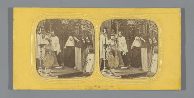 Schwarzes und weißes Foto einer Gruppe von Menschen in traditioneller russischer Kleidung auf einer Bühne, die fröhlich lächeln.