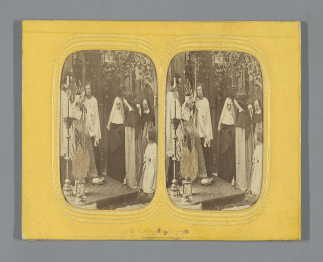 Schwarzes und weißes Foto einer Gruppe von Menschen in traditioneller russischer Kleidung auf einer Bühne, die fröhlich lächeln.