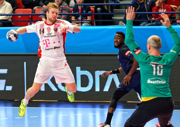 Eine Gruppe von Männern spielt Handball auf einem Feld während des Futsal-Weltmeisterschaftsspiels 2019 zwischen Bayern München und Paris Saint-Germain, mit Zuschauern im Hintergrund.